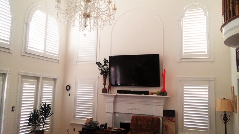 Dallas great room with wall-mounted TV and arched windows.